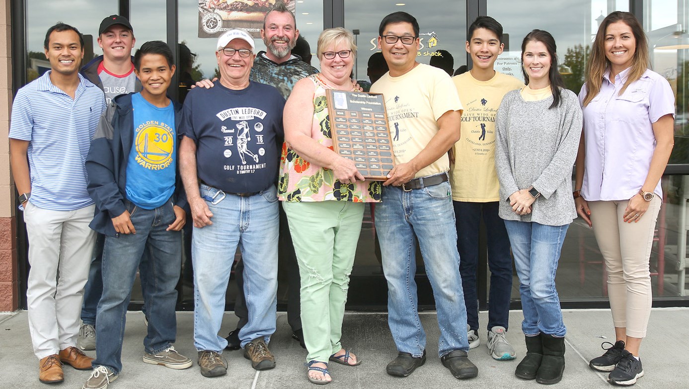 Ledford family presenting the plaque to the Shane's Franchise owners Michael and Julie Aseron.