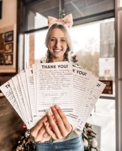 Shane's employee holding thank you cards for our Veteran community